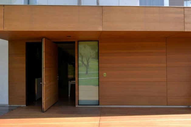 Очаровательная поворотная входная дверь, прикрывающая внешний вид вашего современного дома